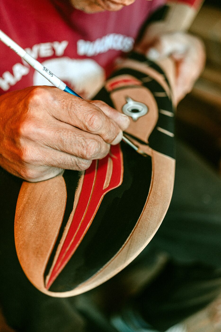 Laying red and black paint into the carved formline